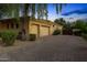 Spacious three-car garage with a large brick driveway and mature landscaping at 2799 E Jade Pl, Chandler, AZ 85286
