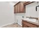 A laundry room featuring wooden cabinets, a sink, and hookups for laundry machines at 2799 E Jade Pl, Chandler, AZ 85286
