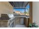 This covered outdoor kitchen features stainless steel grill and prep area with a refrigerator and granite counters at 2799 E Jade Pl, Chandler, AZ 85286