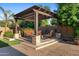 Inviting covered outdoor living space complete with stone accents, comfortable seating, and manicured landscaping at 2799 E Jade Pl, Chandler, AZ 85286