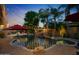 Backyard pool with grotto waterfall and lush landscaping, surrounded by resort-style amenities at 2799 E Jade Pl, Chandler, AZ 85286