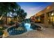 A freeform pool is surrounded by lush landscaping and a patio that is perfect for entertaining at 2799 E Jade Pl, Chandler, AZ 85286