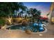 A freeform pool with grotto waterfall is surrounded by lush landscaping and a spacious patio at 2799 E Jade Pl, Chandler, AZ 85286