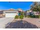 Charming home showcasing a lush landscaped yard, an attached garage, and a decorative front door at 3020 E Tiffany Way, Gilbert, AZ 85298