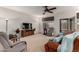 Inviting living room boasts comfortable seating, natural light, an accent cabinet and a ceiling fan at 3020 E Tiffany Way, Gilbert, AZ 85298