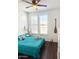 Bright bedroom with a ceiling fan, natural light, and beach-themed decorations for a relaxing, coastal vibe at 357 E Las Puertas Ln, Queen Creek, AZ 85140