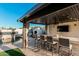 Chic outdoor bar area with comfortable seating and modern lighting, perfect for entertaining by the pool and fireplace at 4247 E Tonto Pl, Chandler, AZ 85249