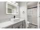 Bathroom features vessel sink with modern faucet and tiled shower with glass doors at 5209 W Hatcher Rd, Glendale, AZ 85302