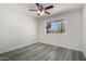 Bright bedroom with a large window offering views of the neighborhood and stylish, modern flooring at 5209 W Hatcher Rd, Glendale, AZ 85302