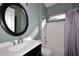 Cozy bathroom featuring a vanity with sink, a round mirror, and a shower-tub combo at 5405 S Marigold Way, Gilbert, AZ 85298