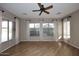 Bright living room with wood floors, a ceiling fan, three windows, and neutral paint at 5405 S Marigold Way, Gilbert, AZ 85298