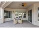 Inviting covered patio with a brick floor, ceiling fan, and a cozy seating area at 5405 S Marigold Way, Gilbert, AZ 85298
