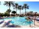 Scenic pool with a rock waterfall, palm trees, and ample seating for residents at 5405 S Marigold Way, Gilbert, AZ 85298