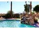 Community pool featuring a rock waterfall, palm trees, and plenty of lounge seating at 5405 S Marigold Way, Gilbert, AZ 85298