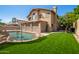 Backyard featuring a pool, desert landscaping, and artificial turf at 5527 W Tonopah Dr, Glendale, AZ 85308