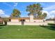 Home exterior featuring a well-manicured lawn, mature trees, and block wall fencing at 6143 E Lewis Ave, Scottsdale, AZ 85257