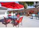 Inviting backyard patio area with ample seating, red umbrella and lush green landscape at 6161 S Oakmont Dr, Chandler, AZ 85249