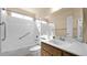 Bright bathroom with a tub-shower combo, featuring a white tile surround and grab bars for added safety at 6713 N 80Th Pl, Scottsdale, AZ 85250