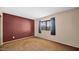 A cozy bedroom features a brown accent wall, carpet flooring and a window at 6713 N 80Th Pl, Scottsdale, AZ 85250