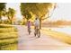 Scenic bike path along the lakefront with mature trees and the sun setting in the background at 6713 N 80Th Pl, Scottsdale, AZ 85250