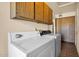Functional laundry room with a washer, dryer, and overhead cabinets for storage, adding convenience to chores at 6713 N 80Th Pl, Scottsdale, AZ 85250