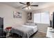 Cozy bedroom featuring a comfortable bed, ceiling fan, neutral color scheme, and a window with natural light at 7018 S 41St Pl, Phoenix, AZ 85042
