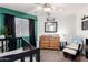 Comfortable Bedroom with a changing table, crib, accent chair and green accent wall at 7018 S 41St Pl, Phoenix, AZ 85042