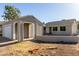 Charming single-story home featuring a detached garage, concrete retaining wall, and well-lit entryway on a clear, sunny day at 7018 S 41St Pl, Phoenix, AZ 85042