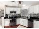 Modern kitchen featuring white cabinets, stainless steel appliances, black countertops, and a stylish backsplash at 7018 S 41St Pl, Phoenix, AZ 85042