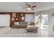 Inviting living room with cozy sectional sofa, wood-paneled wall, ceiling fan, and sliding glass doors leading to the backyard at 7018 S 41St Pl, Phoenix, AZ 85042