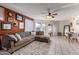 Comfortable living room featuring a sectional sofa, wood accent wall, ceiling fan, and bright natural light at 7018 S 41St Pl, Phoenix, AZ 85042