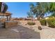 Landscaped backyard featuring a built-in hot tub, gravel, stone pavers, and mature shade trees at 7232 E Nance St, Mesa, AZ 85207