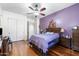 Primary bedroom featuring a ceiling fan, hardwood floors, and ensuite bathroom with walk-in closet at 7232 E Nance St, Mesa, AZ 85207