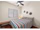 Bright bedroom with wood floors, ceiling fan and large window, creating an inviting space at 7232 E Nance St, Mesa, AZ 85207