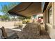 Backyard with hot tub, paver patio, and awning, creating a private and relaxing outdoor space at 7232 E Nance St, Mesa, AZ 85207
