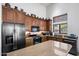 Close-up of kitchen features stainless appliances, granite countertops, and cherry cabinets at 7232 E Nance St, Mesa, AZ 85207