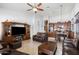 Comfortable living space featuring tile flooring, a large entertainment center, and open access to the kitchen at 7232 E Nance St, Mesa, AZ 85207
