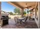 Covered patio includes a ceiling fan, BBQ grill, outdoor furniture and views of the backyard at 7232 E Nance St, Mesa, AZ 85207