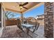 Outdoor patio with stone columns, ceiling fan, and a dining table for entertaining at 7232 E Nance St, Mesa, AZ 85207