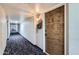 Hallway with carpet leading to unit 403's decorative brown front door at 7940 E Camelback Rd # 403, Scottsdale, AZ 85251