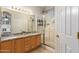 Well-lit bathroom featuring dual sinks, a granite countertop, and glass shower at 817 S 123Rd Dr, Avondale, AZ 85323
