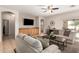 Spacious living room with tile flooring, neutral colored furnishings, and a built-in entertainment center at 817 S 123Rd Dr, Avondale, AZ 85323