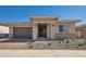 Charming single-story home featuring stone accents, a two-car garage, and well-maintained landscaping at 855 W Peralta Pass, Apache Junction, AZ 85120