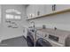 Bright laundry room with modern washer/dryer, cabinets, and fun 'Laundry Today' wall decor at 9167 E Tarantini Ln, Scottsdale, AZ 85260
