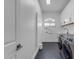 Well-lit laundry room with modern appliances, wall decor, white cabinets and hex tile floor at 9167 E Tarantini Ln, Scottsdale, AZ 85260