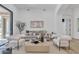 Stylish living room featuring a modern sofa, white chairs, and neutral decor with wood flooring at 9167 E Tarantini Ln, Scottsdale, AZ 85260