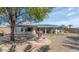 Landscaped backyard featuring mature trees, a decorative water fountain, and solar panels on the roof at 9401 W Raintree Dr, Sun City, AZ 85351