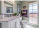 Bright bathroom featuring a marble countertop vanity and ample natural light from the large window at 9401 W Raintree Dr, Sun City, AZ 85351