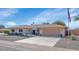 Ranch-style home with a two-car garage, well-manicured lawn, and American flag at 9401 W Raintree Dr, Sun City, AZ 85351