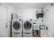 Functional laundry room with side-by-side washer and dryer, a utility sink, and ample storage space at 9401 W Raintree Dr, Sun City, AZ 85351